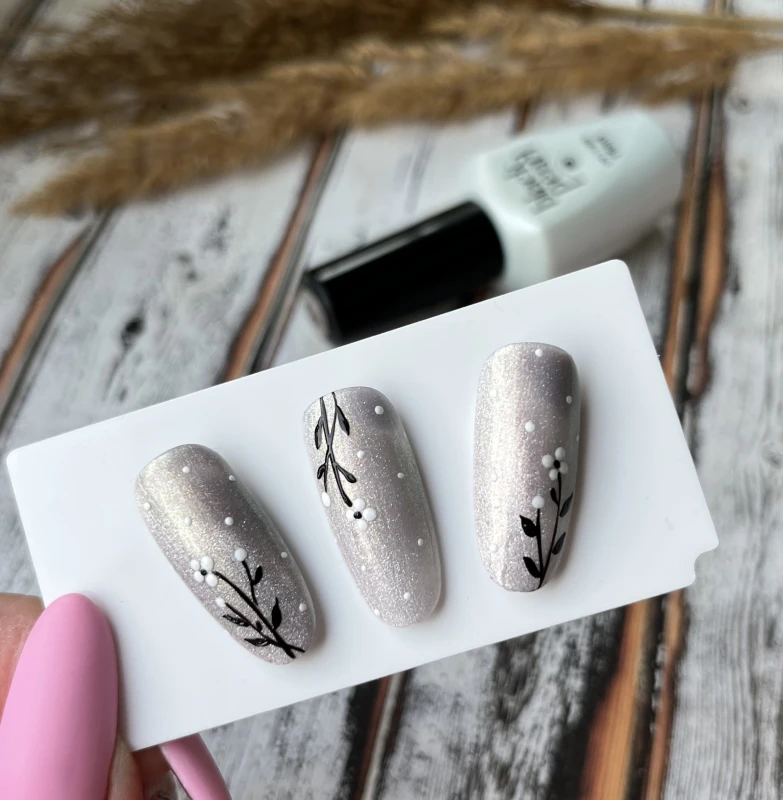 złote paznokcie hybrydowe stylizacja cat eye na dłoni